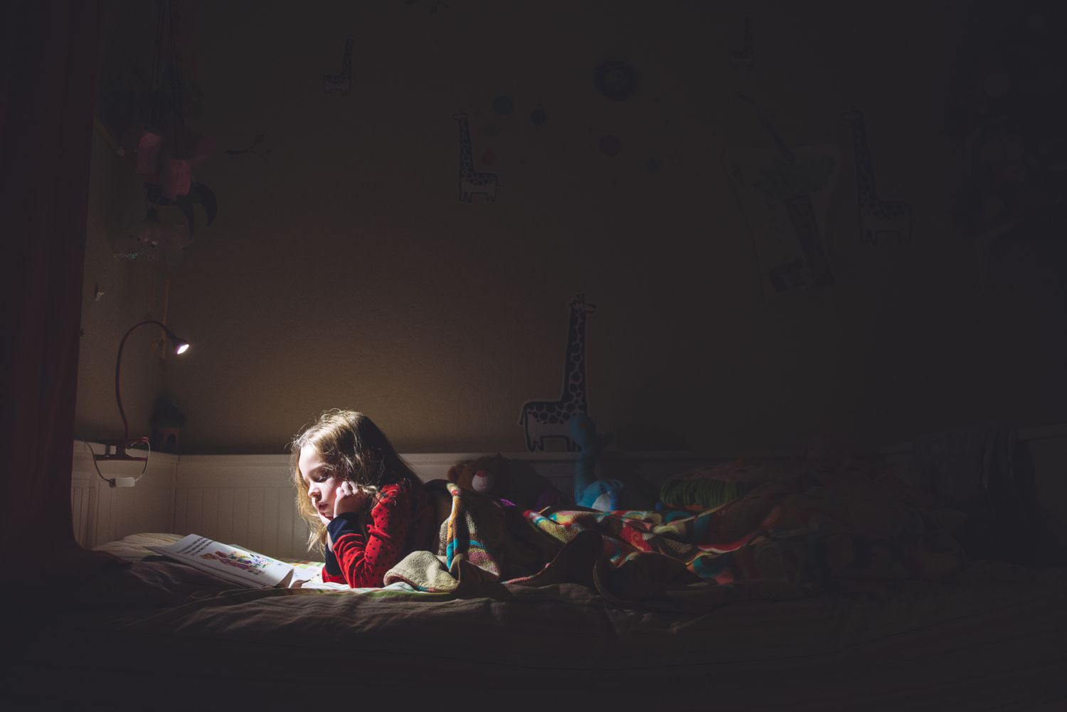 Girl reading in bed at night