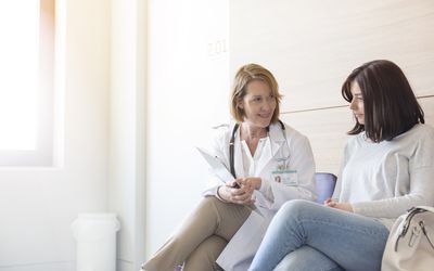 Doctor and patient reviewing medical record in clinic lobby