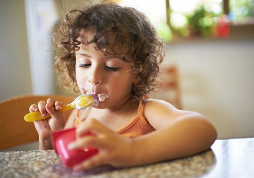 Toddler eating yogurt
