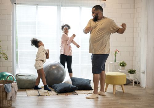 Father and his two daughters exercising at home