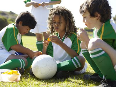 boys eating orange slices at halftime during soccer game