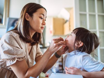 A mom using an at-home COVID-19 test on her toddler