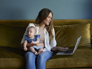 Mother looks at her laptop as she thinks about going back to work.