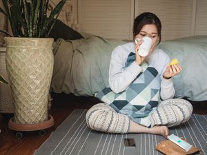 一名女子在卧室里拿着月经杯喝水