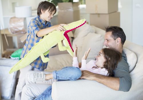 Dad and kids playing among moving boxes