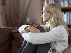 心烦意乱的女人坐在沙发上看着窗外