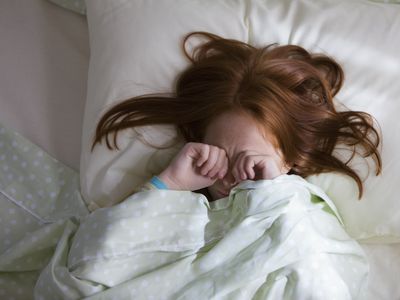 Sleepy Caucasian girl laying in bed