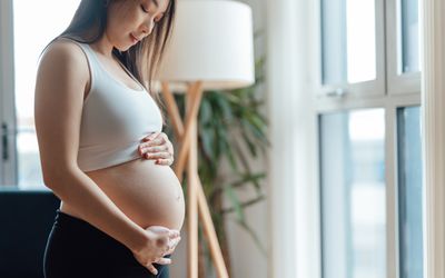 孕妇低头盯着怀孕的肚子。