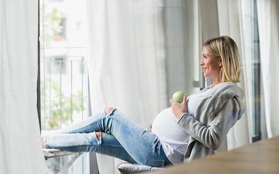 孕妇坐在椅子上吃青苹果