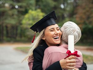 高中毕业生抱着文凭拥抱妈妈