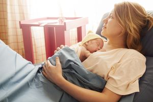 Premature baby girl resting on mother's breasts