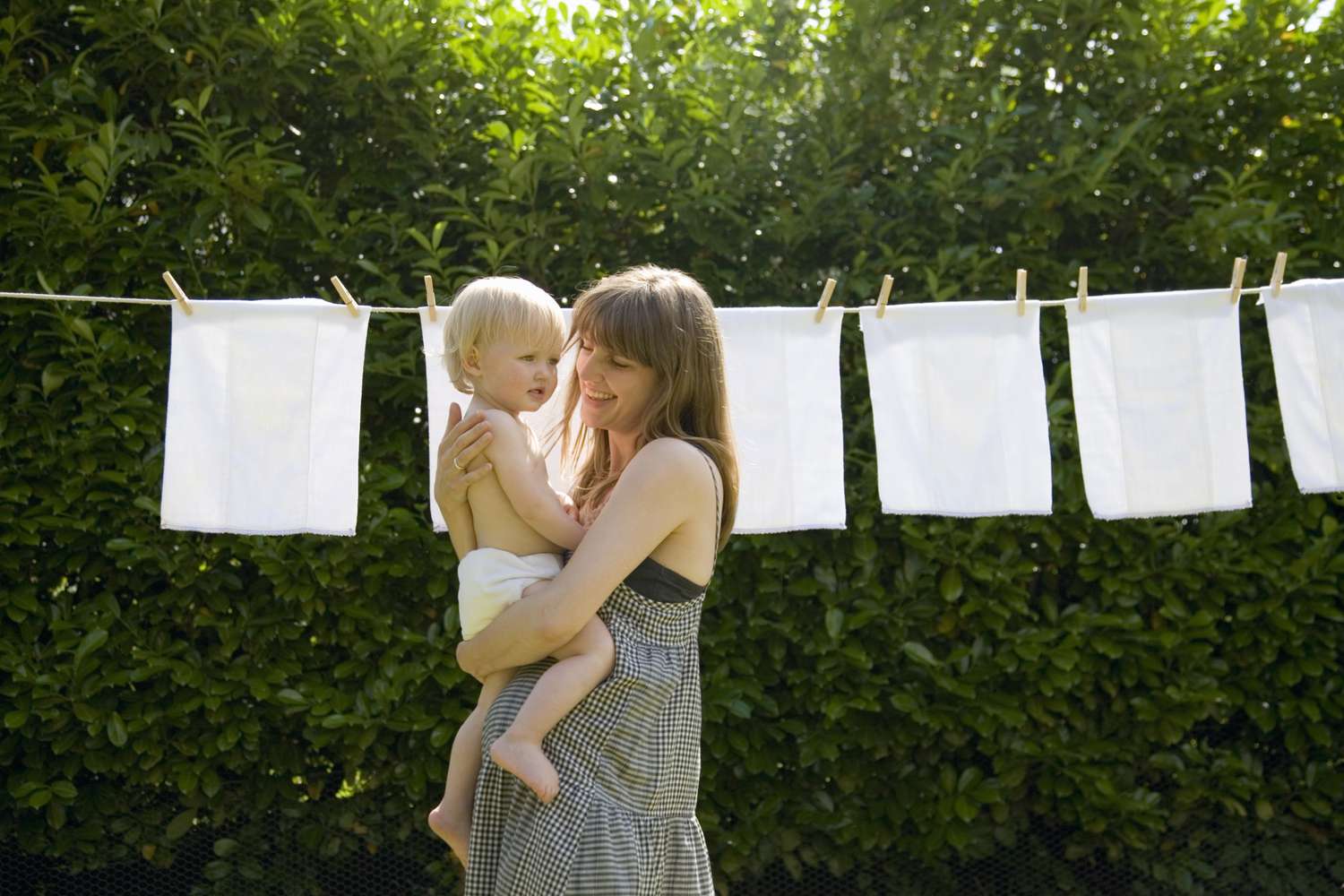 mother and baby in front of diapers on clothesline