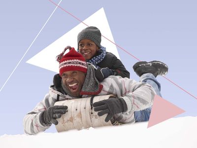 A man and child on a sled in the snow