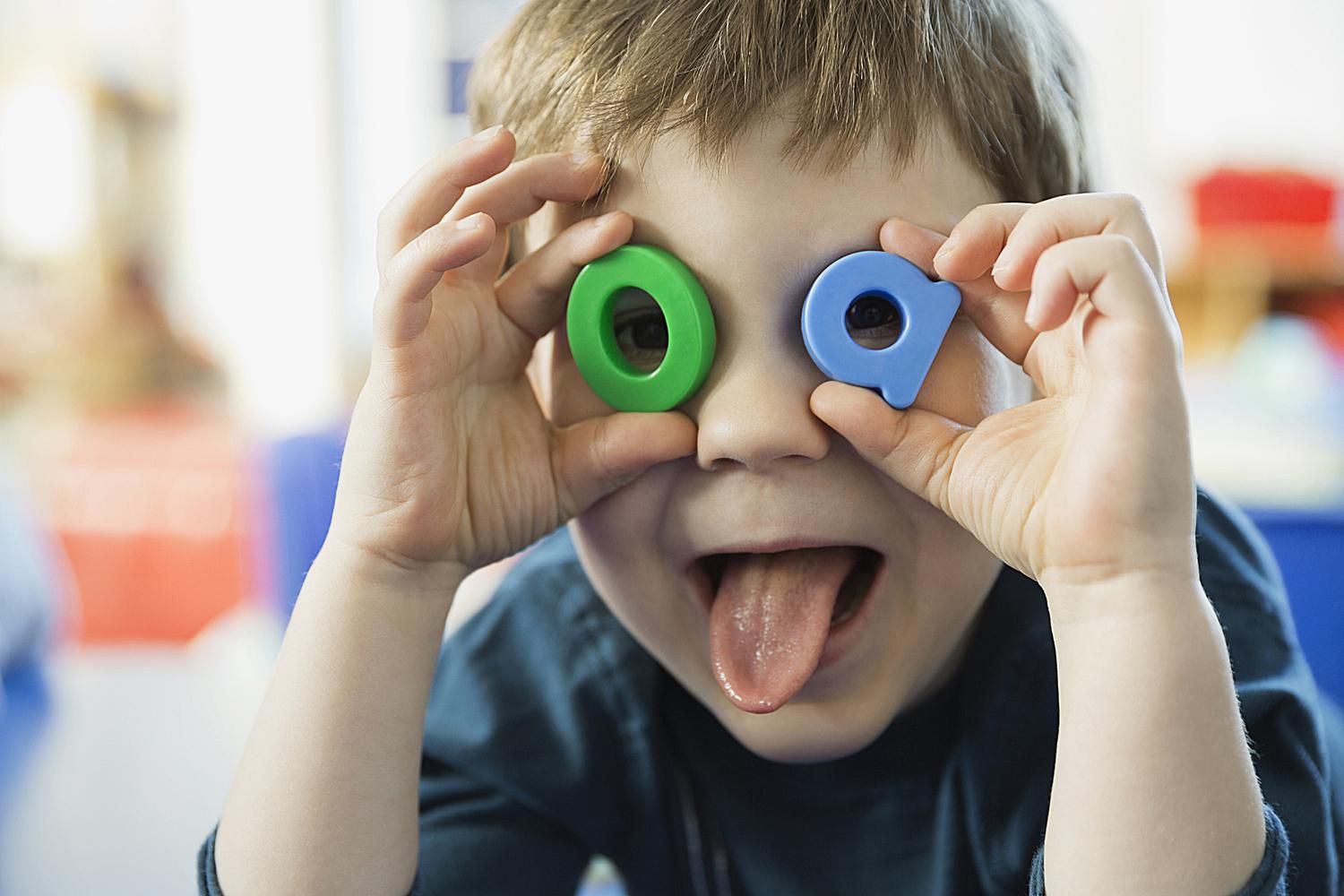 Boy playing with letters in a classroom.