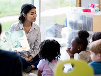 Librarian reads children a book during story time