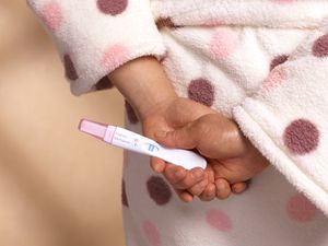 一个女人手里拿着验孕棒的特写镜头华体会体育官方人口