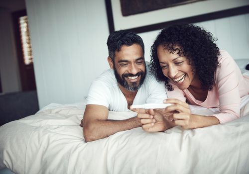 A smiling couple looking at a pregnancy test