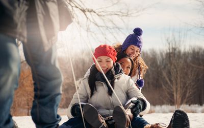 Teenagers being pulled on a sled