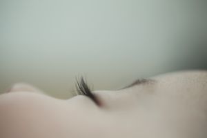 白色婴儿熟睡的脸部特写。睫毛突出，略见眉尾