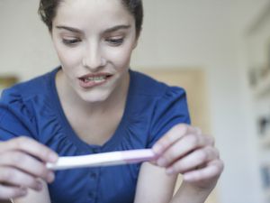 妇女拿着家里的验孕棒，看起来很担心华体会体育官方人口