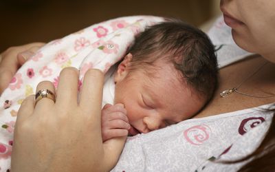 Mother holding premature baby.