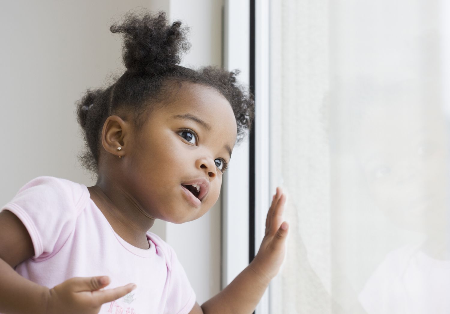 African American girl looking out of a window
