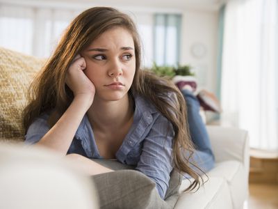 Anxious girl laying on sofa