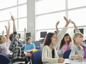 在教室里举手的学生。