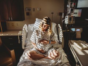 孕妇抱着肚子坐在病床上