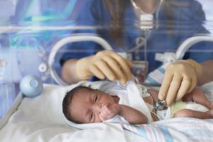 女医生在孵化器里检查新生婴儿