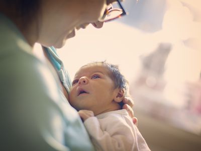 Mom smiling at newborn at hospital