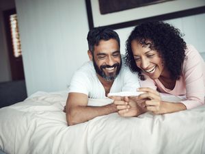 一对微笑的夫妇正在看验孕棒华体会体育官方人口