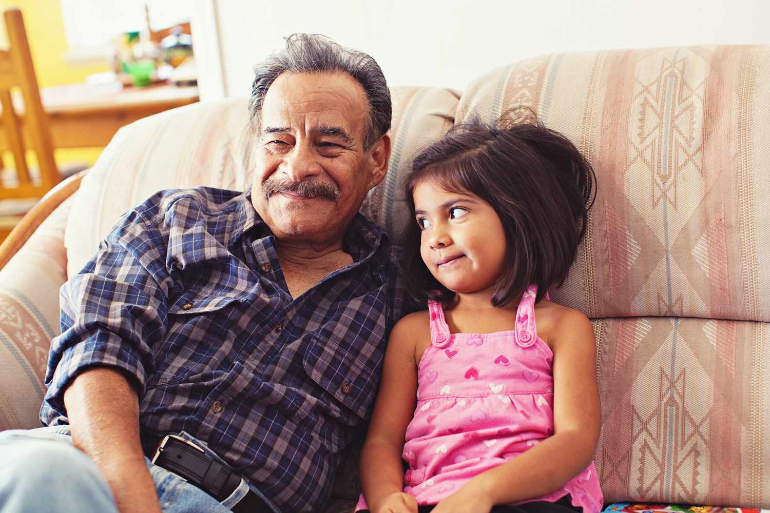Grandfather and Granddaughter Laughing on Couch