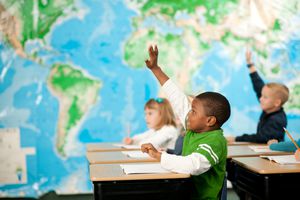 kids raising hands in a first grade classroom