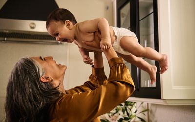 妇女把婴儿举过头顶