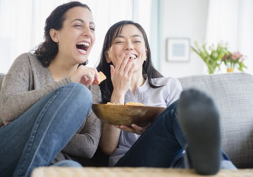 women watching a comedy together during the two week wait, using distraction to cope