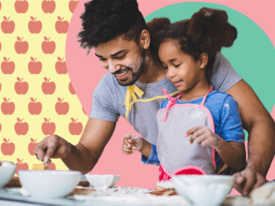 Father helping daughter cook