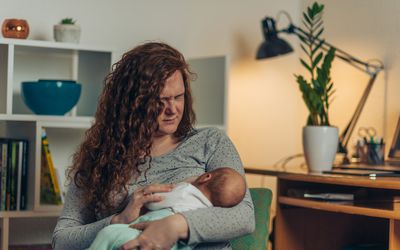Mother in pain breastfeeding her baby