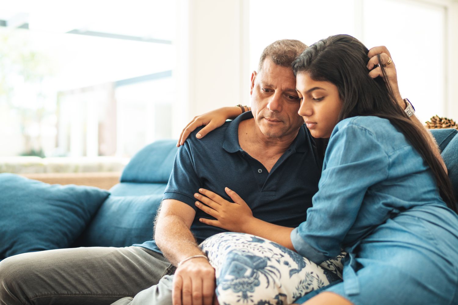 Teenage girl being comforted by a parent
