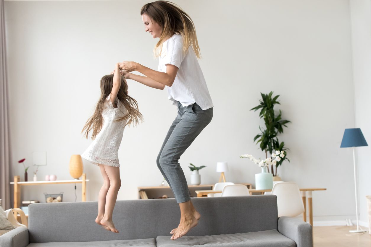 mom and daughter jumping on couch