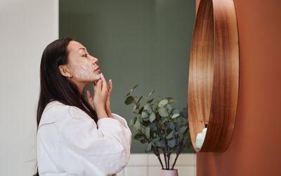 年轻女子在脸上涂保湿霜