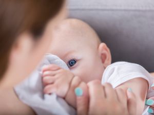 可爱的蓝眼睛宝宝在哺乳时看着妈妈