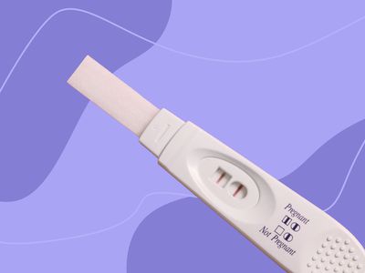 Stick pregnancy test displayed against a purple patterned background