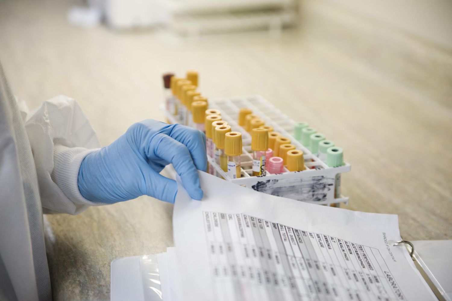 Lab technician with blood samples and medical chart.