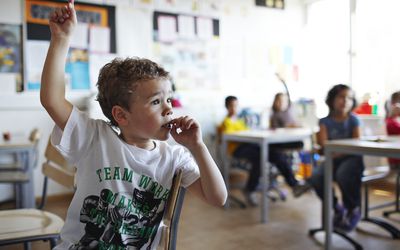 Boy with raised hand in classroom