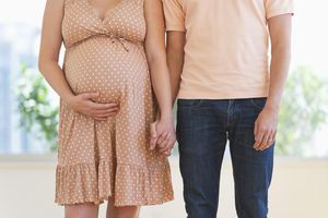 Pregnant woman holding partner's hand