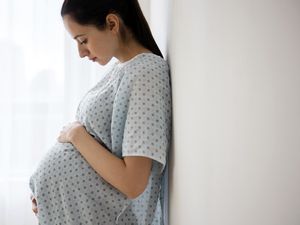 怀孕的白人妇女在医院抱着自己的肚子