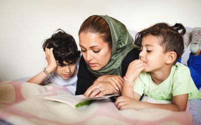 mom-reading-to-her-kids-on-bed