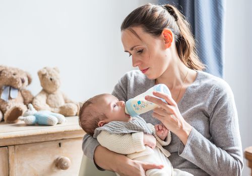 Woman bottle feeding baby
