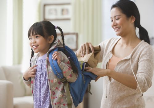 mother helping daughter get ready for school